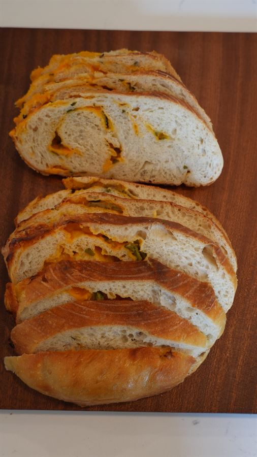 Two halved jalapeño cheddar sourdough loaves